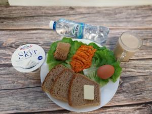 Zdjęcie przedstawia Dietę z ograniczeniem łatwoprzyswajalnych węglowodanów: Masło extra Pasztet wołowo-drobiowy Pasta warzywna Kawa zbożowa z mlekiem Chleb Graham Jogurt typu islandzkiego naturalny Skyr Woda mineralna Sałata zielona Jajko gotowane